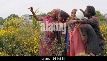 Un groupe d'Indiens heureux mâles et femelles prenant un selfie tout en assistant au festival Holi Banque D'Images