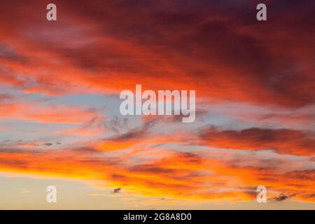 Le coucher du soleil fait briller le ciel en orange, jaune, rouge, bleu, noir, blanc. Banque D'Images