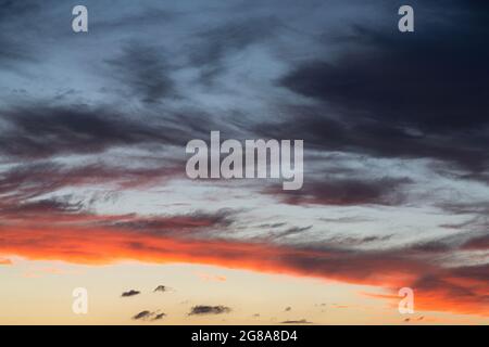 Le coucher du soleil fait briller le ciel en orange, jaune, rouge, bleu, noir, blanc. Banque D'Images