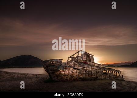 Épave du vieux bateau de pêche. Un vieux naufrage abandonné, naufrage de bateau naufrage se trouve sur la côte de la plage. Coucher de soleil pittoresque. Banque D'Images