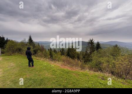 WIELKI Lubon, Pologne - 15 juillet 2021 : un homme non identifié en vêtements noirs, debout près de la falaise, en admirant la vue sur la montagne Lubon Wielki située à Pol Banque D'Images