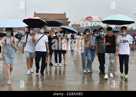 Pékin, Chine. 18 juillet 2021. Les touristes utilisent des parasols lors d'une visite de la place Tienanmen par un jour de pluie.l'Observatoire météorologique de Beijing a amélioré son signal d'avertissement orange en cas de pluie, a temporairement coupé plusieurs routes, a arrêté certains trains et a annulé certains vols. Crédit : SOPA Images Limited/Alamy Live News Banque D'Images