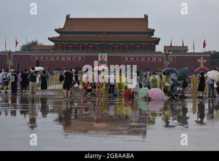 Pékin, Chine. 18 juillet 2021. Les touristes utilisent des parasols lors d'une visite de la place Tienanmen par un jour de pluie.l'Observatoire météorologique de Beijing a amélioré son signal d'avertissement orange en cas de pluie, a temporairement coupé plusieurs routes, a arrêté certains trains et a annulé certains vols. Crédit : SOPA Images Limited/Alamy Live News Banque D'Images