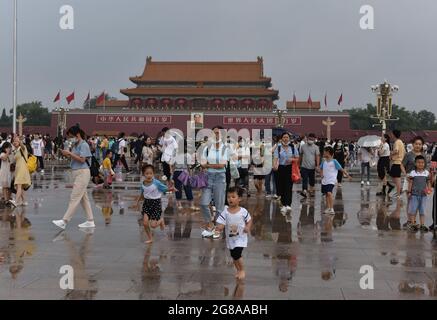 Pékin, Chine. 18 juillet 2021. Les touristes visitent la place Tienanmen par un jour de pluie.l'Observatoire météorologique de Beijing a amélioré son signal d'avertissement orange en cas de pluie, a temporairement coupé plusieurs routes, a arrêté certains trains et a annulé certains vols. Crédit : SOPA Images Limited/Alamy Live News Banque D'Images