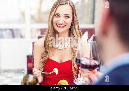 Couple toasting avec vin rouge dans le restaurant romantique Banque D'Images