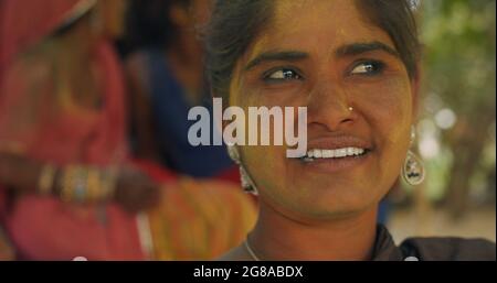 Une femme indienne joyeuse avec de la peinture jaune sur son visage assiste au festival Holi Banque D'Images