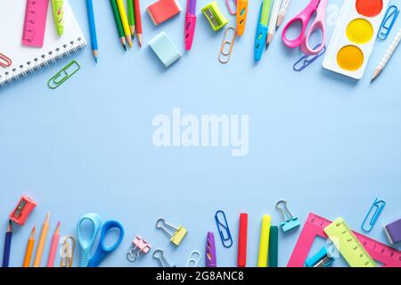 Fournitures scolaires cadre à double bordure sur fond bleu. Concept de retour à l'école. Flat lay, vue de dessus, au-dessus. Banque D'Images