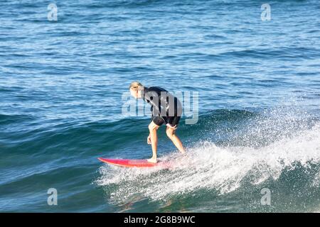 Australien en combinaison surfant sur les vagues à bord de mer à Avalon Beach Sydney, un jour hiverne, Australie Banque D'Images