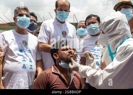 BRAC a lancé des tests rapides Covid-19 à base d'antigènes dans neuf marchés de bétail sous la Dhaka North City Corporation (DNCC) à partir d'aujourd'hui, dimanche 18 juillet. La Direction générale des services de santé (DGHS) fournit le soutien nécessaire à la mise en place d'un coin de Surokkha sur chacun de ces marchés où le personnel du BRAC effectue le service de collecte des échantillons. Le Foreign, Commonwealth & Development Office (FCDO) du gouvernement du Royaume-Uni soutient le BRAC et la DGHS dans cet effort. Le maire de la DNCC, Atiqul Islam, a inauguré les opérations de Surokkha Corners au marché du bétail de Sayeednagar à Bhata Banque D'Images