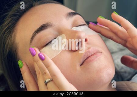 Femme avec des cellules oculaires, se détendre dans le centre de spa. La fille elle-même fait une procédure cosmétique Banque D'Images