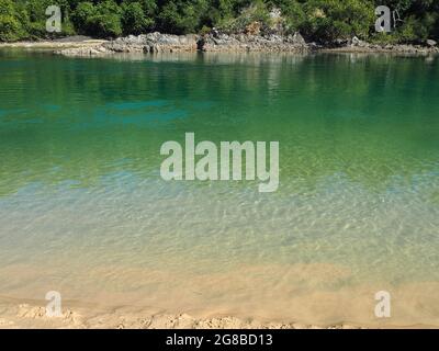 Belle journée ensoleillée en hiver, eau de mer bleu-vert étincelant de soleil dans l'océan Inlet creek, Boambee Reserve sur la côte Nord du centre de la Nouvelle-Galles du Sud Banque D'Images