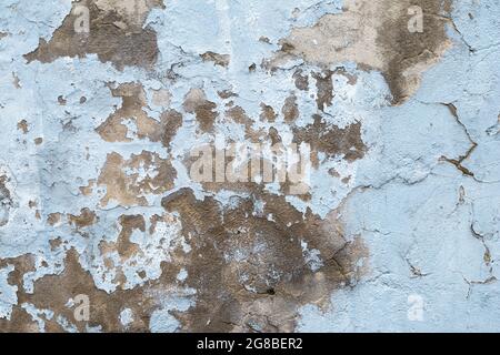 Vieux mur en béton avec peinture écaillée. Gros plan du mur de ciment bleu en ruines. Texture abstraite en stuc grunge. Surface de plâtre fissurée Banque D'Images