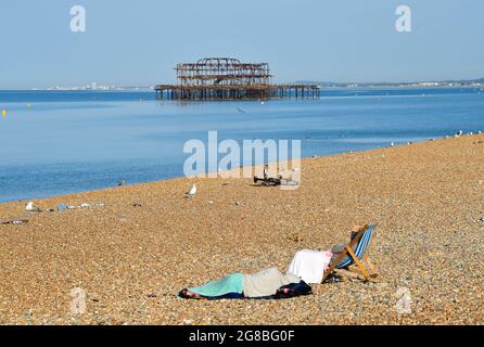 Brighton Royaume-Uni 19 juillet 2021 - temps pour un mensonge sur la plage de Brighton un autre jour ensoleillé comme le temps chaud devrait se poursuivre au cours des prochains jours en Grande-Bretagne avec des températures qui devraient atteindre plus de 30 degrés centigrade dans certaines régions : Credit Simon Dack / Alamy Live News Banque D'Images