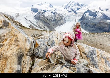 mère et fille avec sac à dos assis sur le sentier dans les montagnes à l'heure de la journée. Banque D'Images