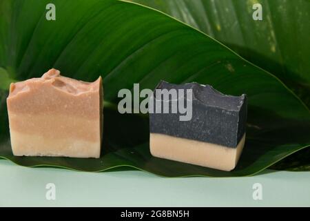 Gros plan de quelques barres de savon faites à la main sur une feuille verte Banque D'Images