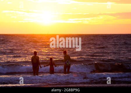 Lever du soleil à Helen’s Bay, Co. Down, tandis que les gens nagent dans la mer d’Irlande pour voir le jour le plus long de l’année sur le solstice d’été. Banque D'Images