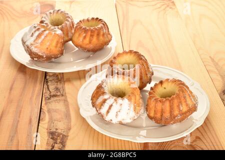 Plusieurs petits gâteaux faits maison sur deux assiettes blanches, en gros plan, sur une table en bois. Banque D'Images