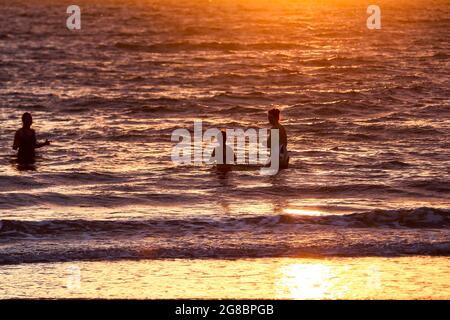 Lever du soleil à Helen’s Bay, Co. Down, tandis que les gens nagent dans la mer d’Irlande pour voir le jour le plus long de l’année sur le solstice d’été. Banque D'Images