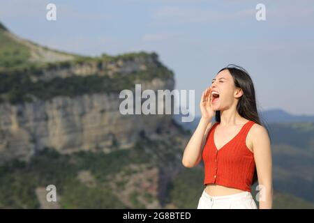 Une femme asiatique criait bruyamment dans la montagne pendant les vacances d'été Banque D'Images