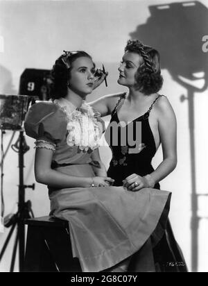 DORIS NOLAN (en HAUT DE LA VILLE sorti en 1937) donne des conseils de maquillage à DEANNA DURBIN lors de sa visite sur le plateau pendant le tournage de TROIS FILLES INTELLIGENTES réalisateur Henry KOSTER producteur associé Joe Pasternak Universal Pictures 1936 Banque D'Images