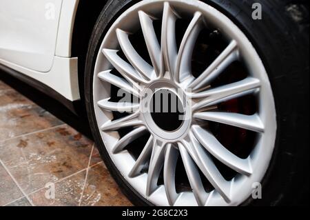 Roues de nouvelle voiture sport de luxe blanche dans un garage de détail. Banque D'Images