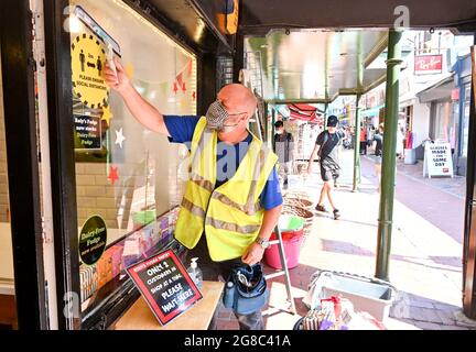 Brighton UK 19 juillet 2021 - ce nettoyeur de fenêtre décide de continuer à porter un masque tout en travaillant à Brighton que les restrictions de verrouillage COVID-19 sont levées en Angleterre sur ce qui est devenu connu sous le nom de Freedom Day: Crédit Simon Dack / Alay Live News Banque D'Images