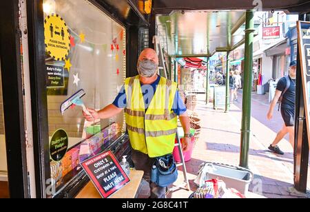 Brighton UK 19 juillet 2021 - ce nettoyeur de fenêtre décide de continuer à porter un masque tout en travaillant à Brighton que les restrictions de verrouillage COVID-19 sont levées en Angleterre sur ce qui est devenu connu sous le nom de Freedom Day: Crédit Simon Dack / Alay Live News Banque D'Images