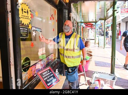 Brighton UK 19 juillet 2021 - ce nettoyeur de fenêtre décide de continuer à porter un masque tout en travaillant à Brighton que les restrictions de verrouillage COVID-19 sont levées en Angleterre sur ce qui est devenu connu sous le nom de Freedom Day: Crédit Simon Dack / Alay Live News Banque D'Images