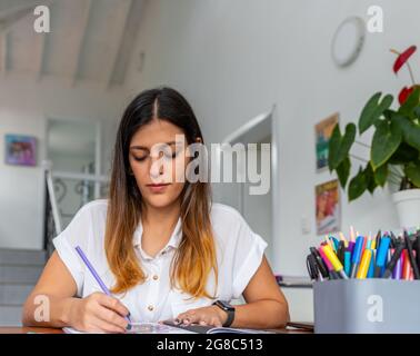 jeune femme colorant des mandalas pour se détendre dans son bureau à la maison Banque D'Images