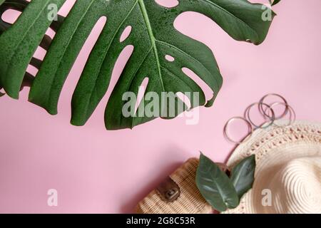 Gros plan de la feuille naturelle et des accessoires pour femmes sur fond rose, vue du dessus. Banque D'Images