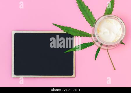 Vue de dessus de la crème de chanvre de cannabis avec feuille de marijuana avec noir tableau vide pour le texte, maquette Banque D'Images