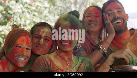 Groupe de personnes gaies aux visages teints participant au festival Holi Banque D'Images