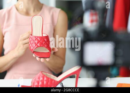 Femme blogger montre de nouvelles sandales rouges de la collection été Banque D'Images