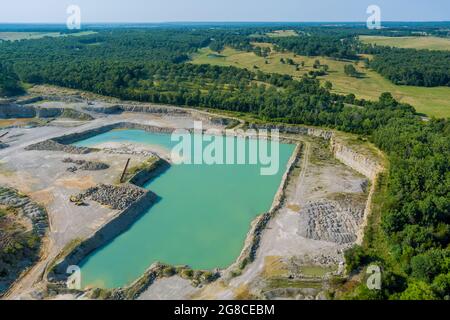 Vue panoramique aérienne en extraction de pierre à ciel ouvert dans le canyon avec un lac vert profond Banque D'Images