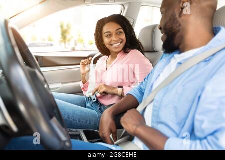 Un heureux couple afro-américain qui met les ceintures de sécurité Banque D'Images