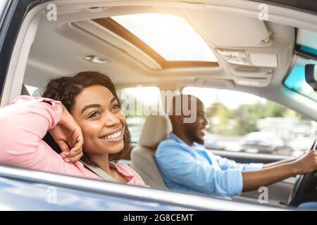 Heureux couple noir appréciant un long trajet sur une voiture Banque D'Images