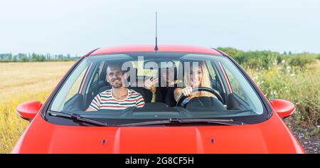 Amis dans une voiture rouge. Concept de liberté de déplacement. Banque D'Images