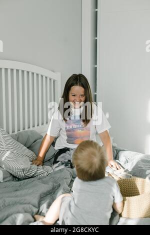 Frère plus jeune et sœur plus âgée passant du temps à la maison ensemble. Famille amicale, concept de style de vie. Banque D'Images