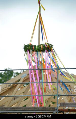 Leipzig, Allemagne. 24 juin 2021. Couronne de garniture sur une maison récemment construite. Cérémonie de remise en forme sur le développement d'un fossé. Une couronne est suspendue à la poutrelle d'une maison récemment construite dans la banlieue de Leipzig. Credit: Volkmar Heinz/dpa-Zentralbild/ZB/dpa/Alay Live News Banque D'Images