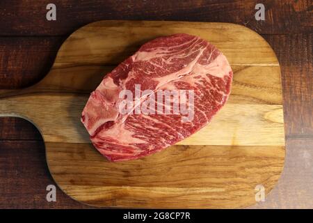 Côte courte ou Costela Premium. Magnifique steak cru sous une planche de bois sur fond de bois. Pour un barbecue brésilien. Banque D'Images