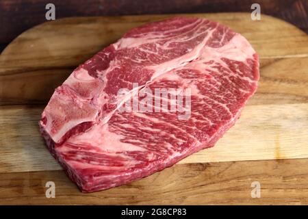 Côte courte ou Costela Premium. Magnifique steak cru sous une planche de bois sur fond de bois. Pour un barbecue brésilien. Banque D'Images