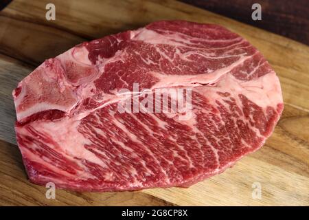 Côte courte ou Costela Premium. Magnifique steak cru sous une planche de bois sur fond de bois. Pour un barbecue brésilien. Banque D'Images
