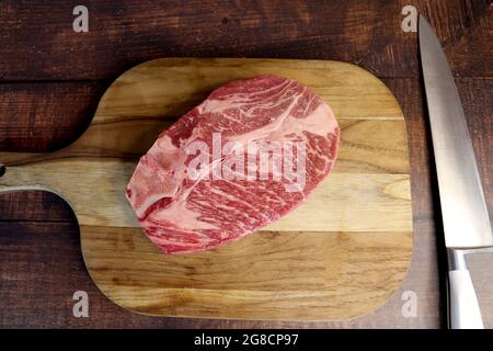 Côte courte ou Costela Premium. Magnifique steak cru sous une planche de bois sur fond de bois. Pour un barbecue brésilien. Banque D'Images