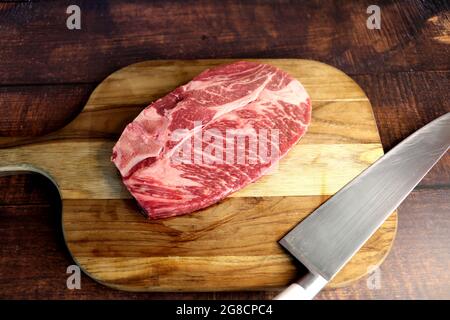Côte courte ou Costela Premium. Magnifique steak cru sous une planche de bois sur fond de bois. Pour un barbecue brésilien. Banque D'Images