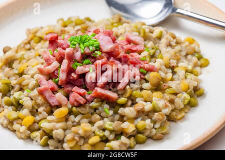 porridge de légumineuses avec bacon frit et ciboulette Banque D'Images