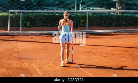 Ankara, Turquie-7 juillet 2013: Une jeune joueuse de tennis féminine se dirige vers la ligne de base pendant l'entraînement sur un terrain d'argile en été. Concept sportif individuel. Banque D'Images