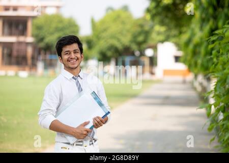 Portrait face à la face avant du jeune étudiant de sexe masculin sur le campus avec espace négatif Banque D'Images