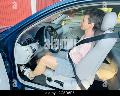Femme sans bras conduisant un coupé Mercedes Benz spécialement adapté avec direction à pied Banque D'Images