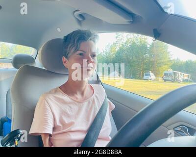 Femme sans bras conduisant un coupé Mercedes Benz spécialement adapté avec direction à pied Banque D'Images