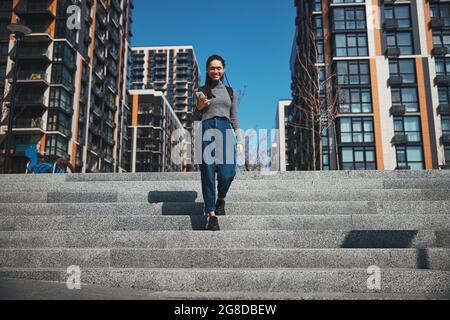 Une femme ravie de descendre les escaliers Banque D'Images